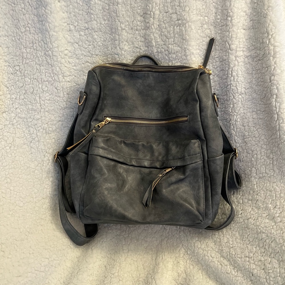 Grey convertible backpack. Can be carried as a purse or used as a backpack.